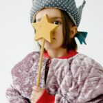 petite fille qui tient une baguette magique